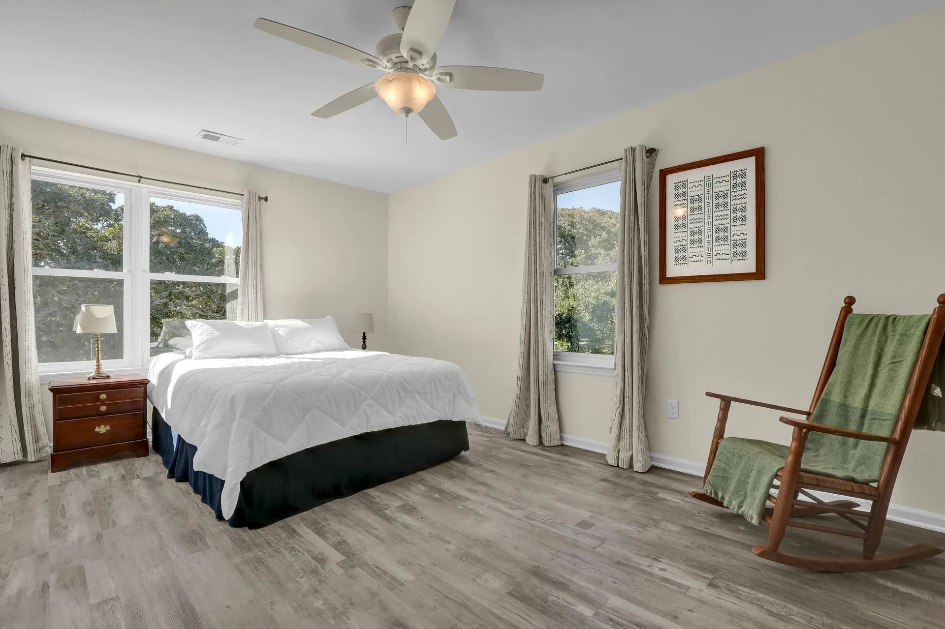 Queen bedroom with rocking chair and twin windows