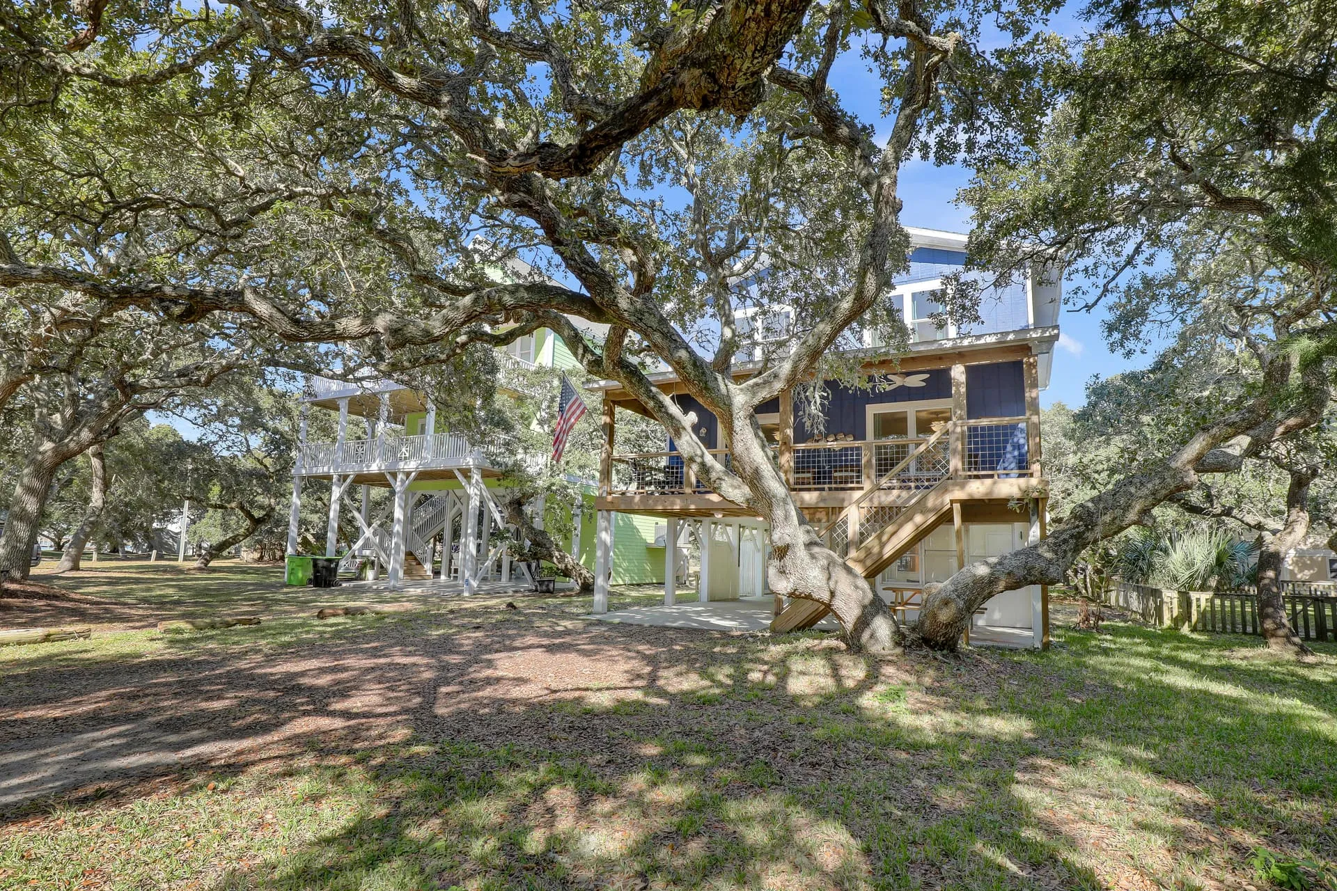 Rear of the house through the oaks with deck and stairs